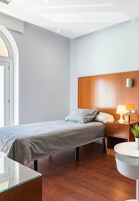 Detalle cama habitación individual premium residencia universitaria en Aranjuez